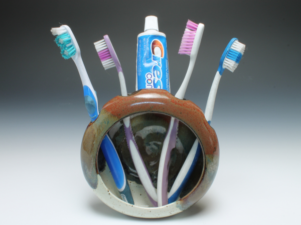 Toothbrush holder with four toothbrushes and toothpaste